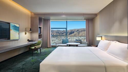 a hotel room with a bed and a large window at Holiday Inn Xining Hot-Spring by IHG in Xining