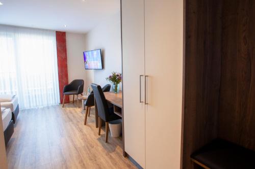 a room with a table and chairs and a cabinet at Haus Hubertus in Winterspelt