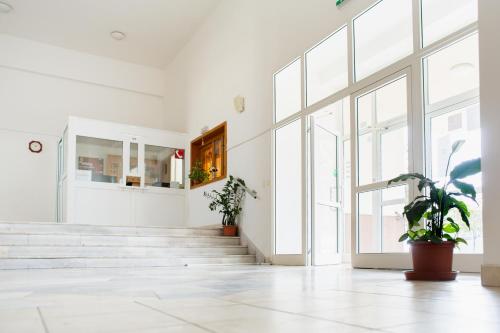 an empty lobby with stairs and potted plants at Danubius Szálló in Komárno