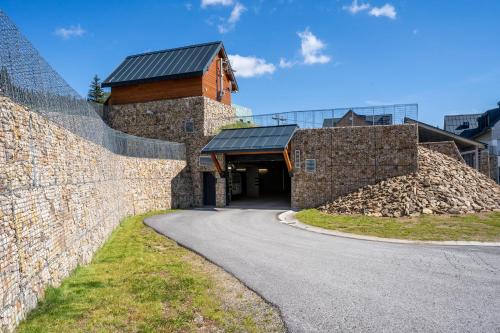 a building with a stone wall next to a road at Apartmán Horní Mísečky - luxusní ubytování pro dvě rodiny s dětmi in Horni Misecky