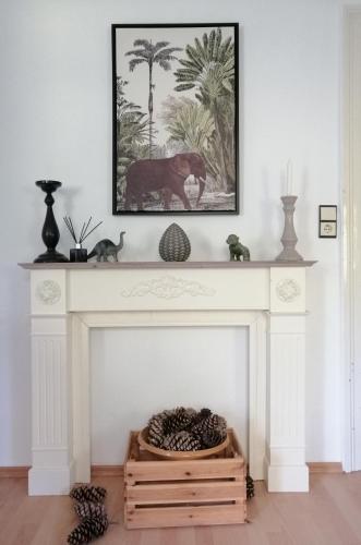 a living room with a fireplace with a picture above it at Villa Elisenruh in Schmalfeld