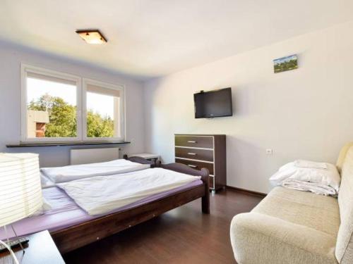 カルパチにあるMaryniaのベッド2台、ソファ、テレビが備わる客室です。
