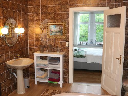 a bathroom with a sink and a bed and a window at Villa Elisenruh in Schmalfeld