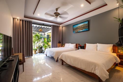Habitación de hotel con 2 camas y TV en hoi an center town en Hoi An