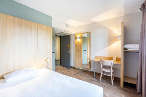 聖錫爾萬當茹的住宿－B&B HOTEL Angers Parc Expos，配有一张床和一张书桌的酒店客房