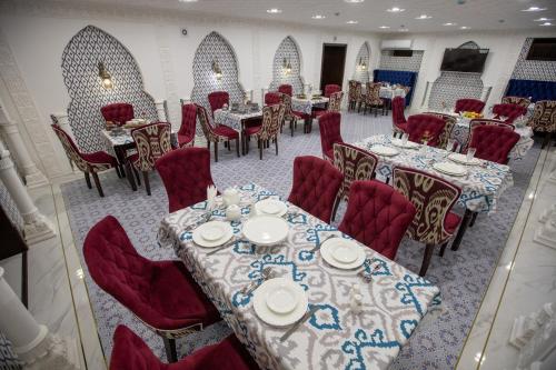 a dining room with tables and red chairs at The Shahar in Tashkent