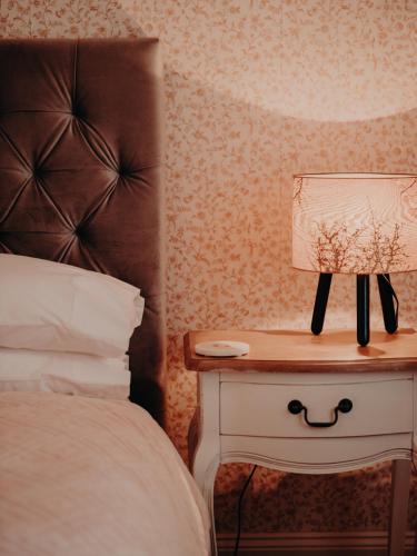 a bedroom with a bed and a lamp on a nightstand at Genesta House in Cowes