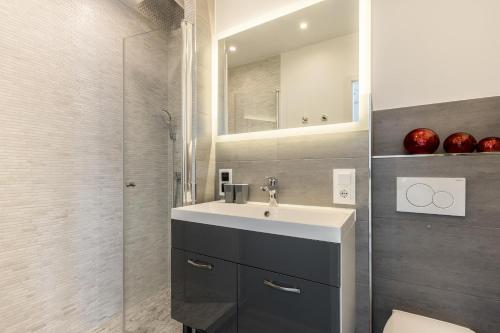 Un baño con lavabo y ducha de cristal. en Ferienwohnung Penthouse, en Westerland