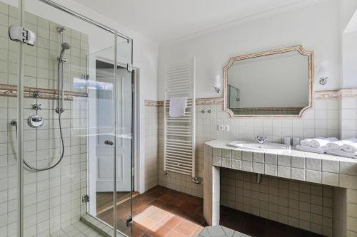 un bagno con doccia, lavandino e specchio di Lenas Hüs a List