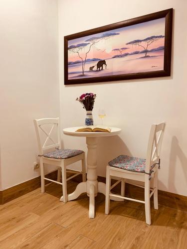 a table with two chairs and a table with a vase of flowers at WINE & ROSE BOUTIQUE HOTEL in Kharkiv
