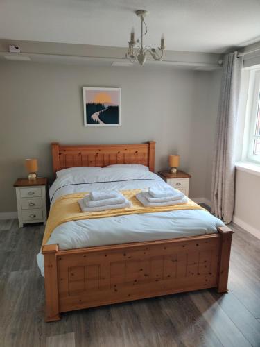 a bedroom with a wooden bed with two night stands at Anchors Away in Ayr