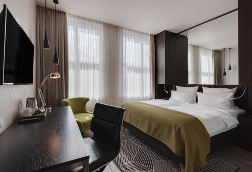 Schlafzimmer mit einem Bett, einem Schreibtisch und einem Stuhl in der Unterkunft Holiday Inn Dresden - Am Zwinger, an IHG Hotel in Dresden