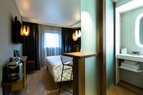 a hotel room with a bed and a desk at Oceania Paris Porte De Versailles in Paris