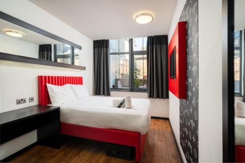 a bedroom with a large bed and a large window at easyHotel Newcastle in Newcastle upon Tyne