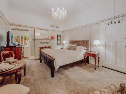 a bedroom with a large bed and a chandelier at Genesta House in Cowes
