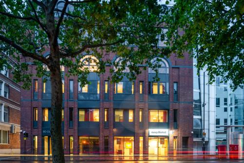 a brick building with lights in the windows at easyHotel London City Shoreditch in London