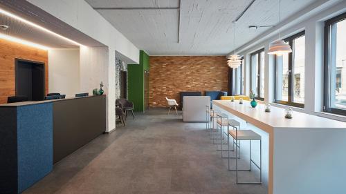 an office with a long bar with stools and windows at The Bunk Hostel in Essen