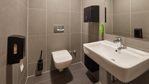 a bathroom with a white sink and a toilet at The Bunk Hostel in Essen