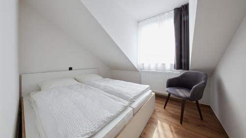 a small bedroom with a bed and a chair at The Bunk Hostel in Essen