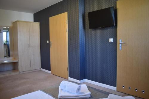 a bedroom with a tv on the wall and a bed at Eco Niebor&oacute;w in Niebor&oacute;w