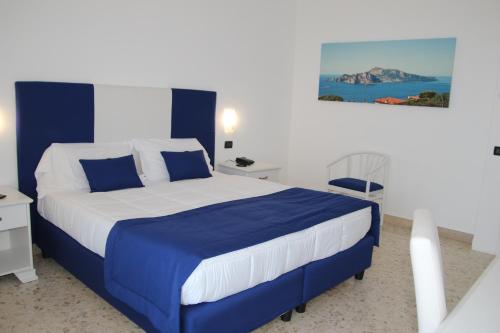 um quarto com uma cama com lençóis azuis e brancos em Hotel Il Nido Sorrento em Sorrento