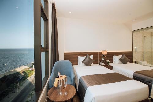 a hotel room with two beds and a view of the ocean at Phương Bắc Luxury Hotel in Dong Hoi