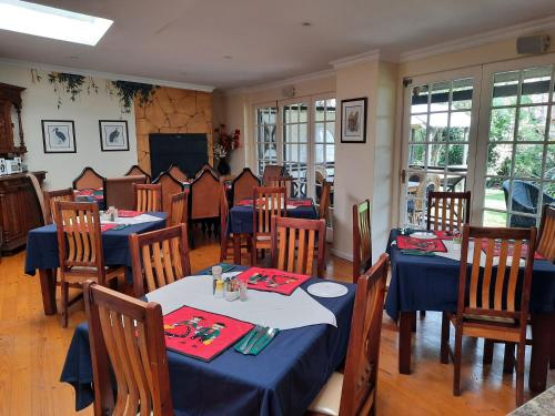 a restaurant with tables and chairs with blue tablecloths at Alpine Inn in George