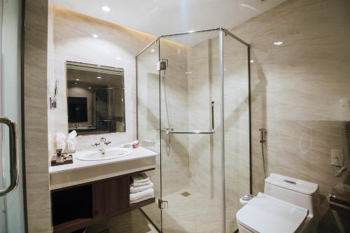 a bathroom with a shower and a toilet and a sink at Phương Bắc Luxury Hotel in Dong Hoi