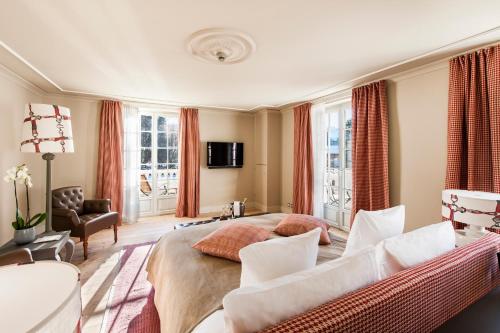 a bedroom with a large bed and a couch at Le Grand Bellevue in Gstaad
