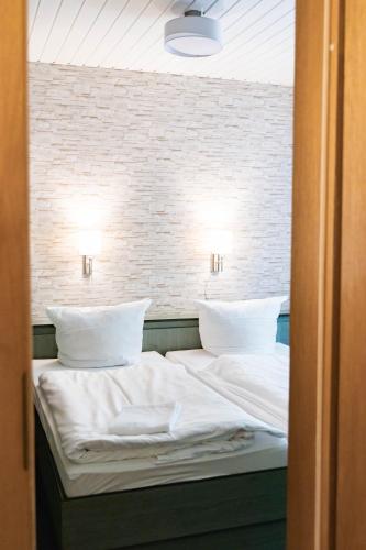 a bedroom with a bed with white sheets and pillows at Gästehaus Chorin in Chorin