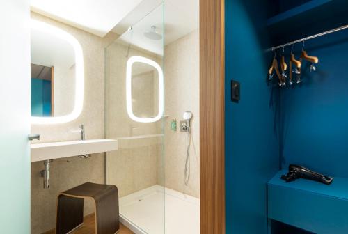 La salle de bains est pourvue d'une douche et d'un lavabo. dans l'établissement Oceania Paris Porte De Versailles, à Paris