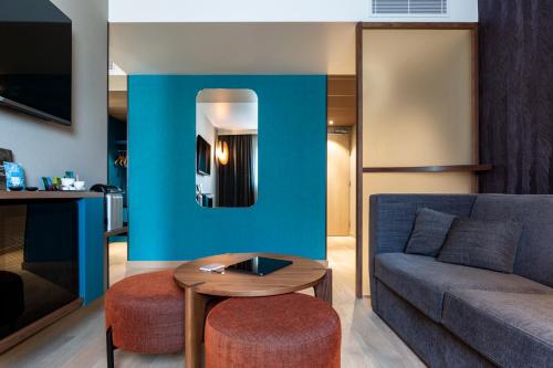 a living room with a couch and a table at Oceania Paris Porte De Versailles in Paris