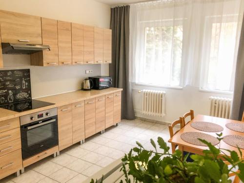 cocina con armarios de madera, mesa y comedor en Hotel Bobr en Chomutov
