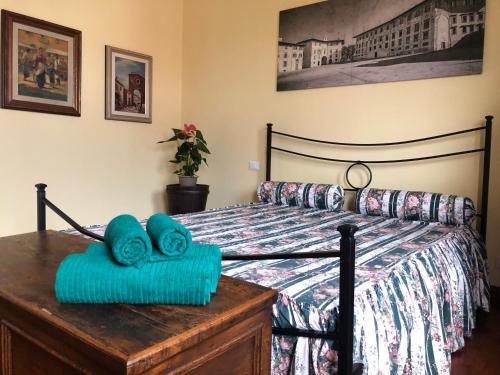 una camera da letto con un letto e asciugamani blu su un comò di Villa Orsini - A Retreat in Pisa - Food and Relax a Pisa