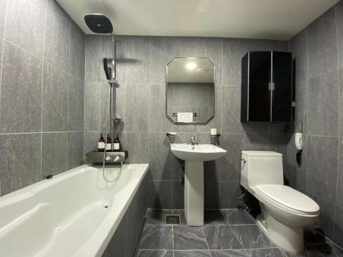 a bathroom with a sink and a toilet and a bath tub at Benikea Daelim Hotel in Daejeon