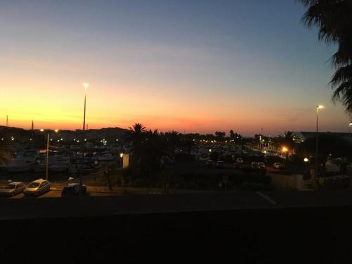 un coucher de soleil avec des voitures garées dans un parking dans l'établissement grand appartement Port Nature 7, au Cap d'Agde