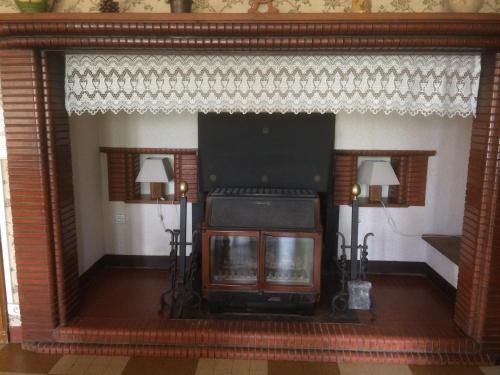 a living room with a fireplace and a tv at Grand gîte de Soumeillan in Castelnau-Magnoac