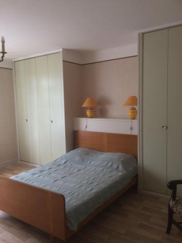 a bedroom with a bed and cabinets and two lamps at Grand gîte de Soumeillan in Castelnau-Magnoac