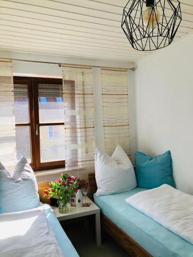 a room with two beds and a table with flowers at Idyllische Ferienwohnungen in Mossendorf in Burglengenfeld