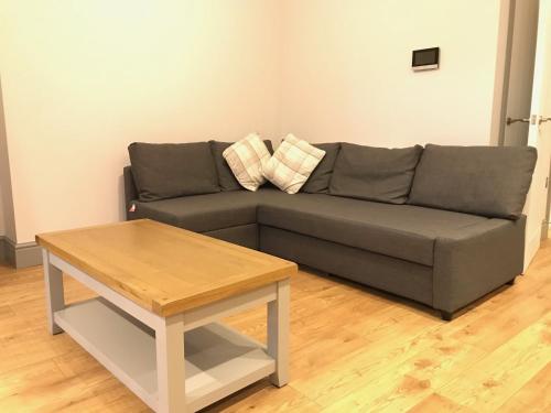 a living room with a couch and a coffee table at Belmont - Y Prom in Aberystwyth