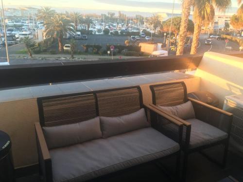 un banc sur un balcon avec vue sur la ville dans l'établissement grand appartement Port Nature 7, au Cap d'Agde