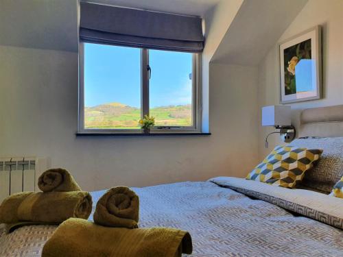 um quarto com uma cama com toalhas em The Granary em Ruthin