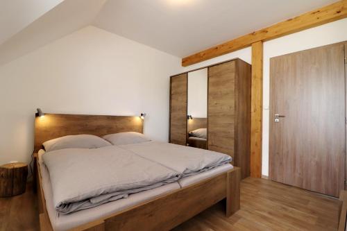 1 dormitorio con 1 cama grande y cabecero de madera en Horské apartmány Na Pastvinách, en Vaclavov u Bruntalu