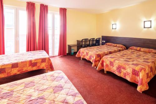 Cette chambre comprend 3 lits avec des rideaux rouges. dans l'établissement Hôtel Estival Arriel, à Lourdes