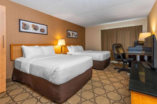 a hotel room with two beds and a desk and a television at Comfort Inn in Pembroke