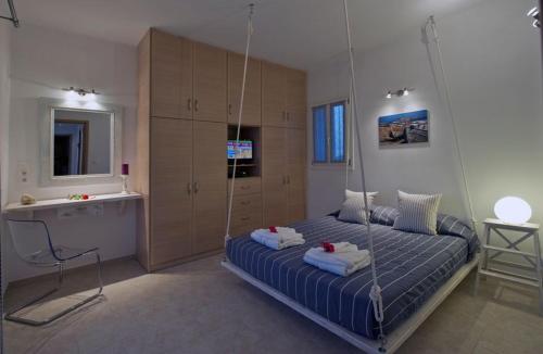 a bedroom with a swing bed and a bathroom at Luxury Paros Villa 2 Bedrooms Villa Royalty Beautiful Sea Views & Private Terrace Naousa in Kampos Paros