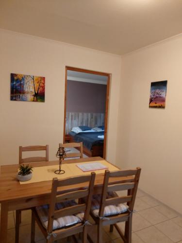 a dining room with a table and chairs and a mirror at Dream Horse Apartman Cserkeszőlő in Cserkeszőlő