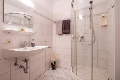 a white bathroom with a sink and a shower at Black Forest Schwarzwaldblick Indoorpool Natur Ruhe Komfort in Höchenschwand