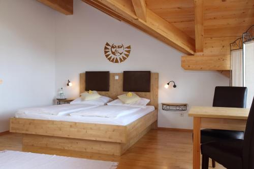 a bedroom with a large bed with a wooden headboard at Gästehaus Burgmayr in Sauerlach