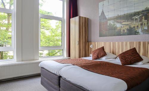 アムステルダムにあるHotel Asterisk, a family run hotelのベッドルーム1室(ベッド2台、窓2つ付)